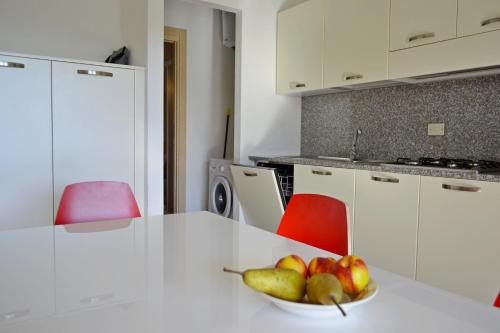 a bowl of fruit on a white counter in a kitchen at GF Apartments La Vigna in Badesi