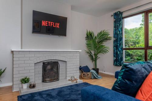 a living room with a blue couch and a fireplace at Templepatrick family home beside the Rabbit hotel in Templepatrick