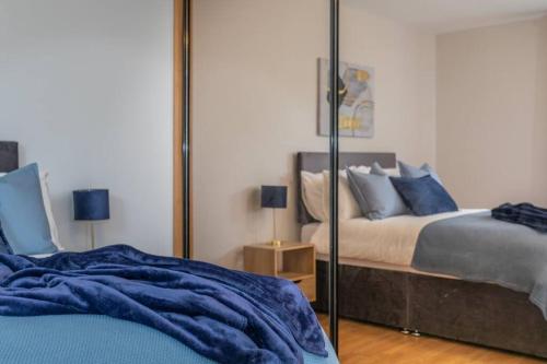 a bedroom with a mirror and a bed with blue pillows at Templepatrick family home beside the Rabbit hotel in Templepatrick