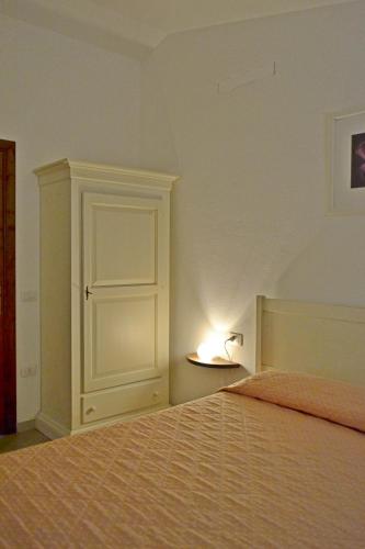 a bedroom with a bed and a lamp on a table at GF Apartments La Vigna in Badesi