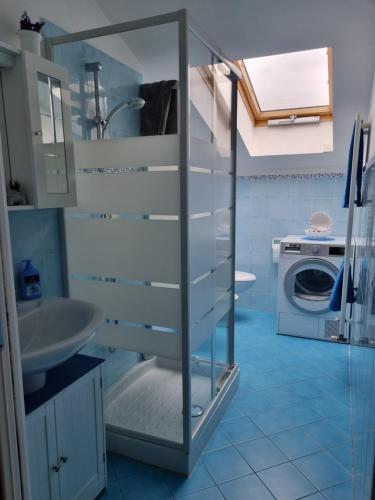 uma casa de banho com um lavatório e uma máquina de lavar roupa em La Mansarda di Noi2 em Spotorno