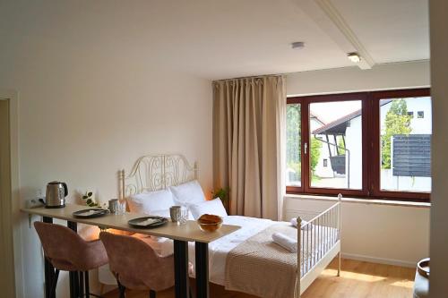 a bedroom with a bed and a table with chairs at Chiemsee Apartments in Altenmarkt an der Alz