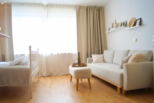 a living room with a white couch and a bed at Chiemsee Apartments in Altenmarkt an der Alz