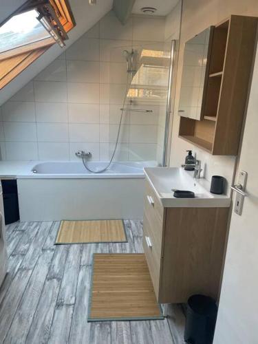 a bathroom with a bath tub and a sink at Le Saint Sauveur - centre ville in Péronne