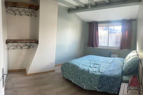 1 dormitorio con cama y ventana en Maison à 2 pas du centre ville, en Péronne