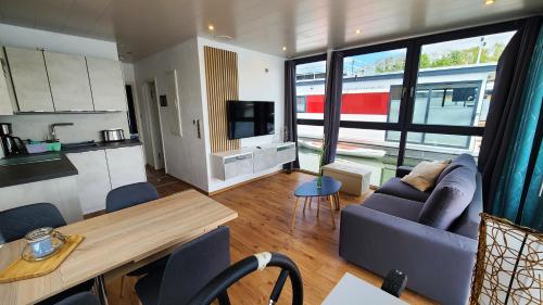 a living room with a blue couch and a kitchen at Hausboot Joana in Zehdenick