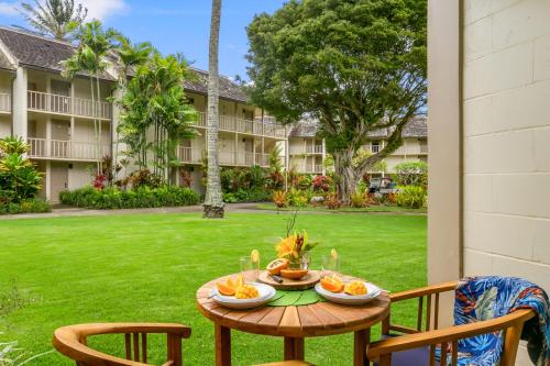 a table with two bowls of fruit on a patio at Islander Ocean Resort Condo # 166 in Kapaa