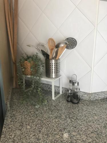 a counter with a pot of utensils on a table at Alojamiento Fragata Lealtad in Moaña