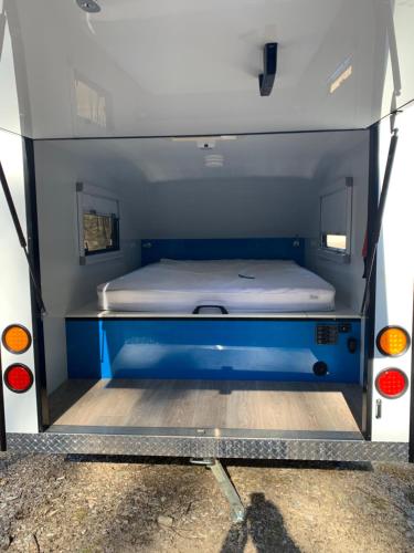 uma cama na parte de trás de uma carrinha em Jindabyne caravan hire em Jindabyne