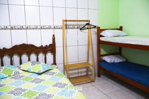 a room with two bunk beds and a bed sidx sidx sidx at Recanto Pousada JU&JU com piscina COMPARTILHADA in Pontal do Paraná