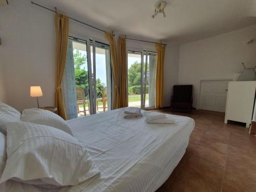 a large white bed in a room with windows at Sea Satin Anavyssos in Anavissos