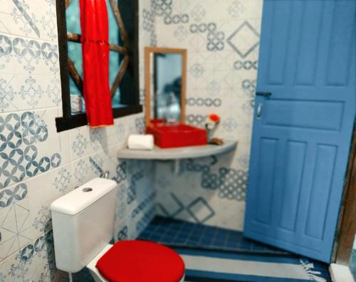 baño con aseo rojo y puerta azul en Promoção Semana Santa em Santo André - Casa da Floresta en Santo André