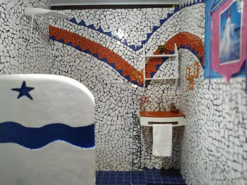 a bathroom with a sink and a mosaic wall at Casa da Floresta Santo André in Santo André
