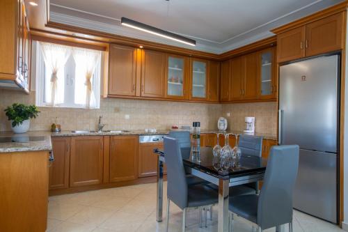a kitchen with a table and a stainless steel refrigerator at Adria Luxury Apartments in Nydri