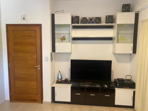 a room with a television on a desk with a door at Alojamiento Necochea in La Banda