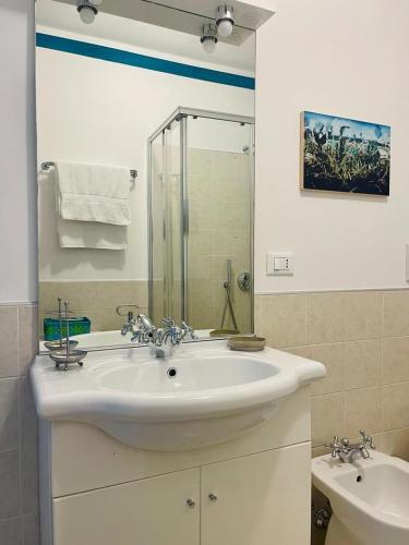 a white bathroom with a sink and a shower at Miralago Casa Vacanze in Riva di Solto