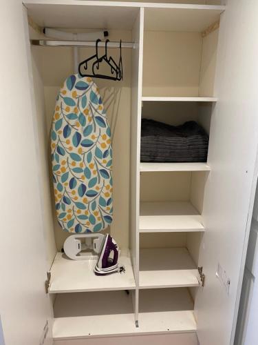 a surfboard is sitting on a shelf in a closet at Single Room only for one adult in Southall