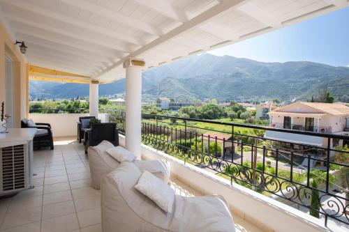 a balcony with white furniture and a view of mountains at Adria Luxury Apartments in Nydri