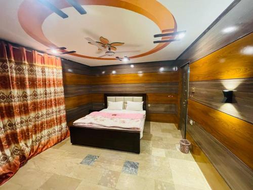 - une chambre avec un lit dans une pièce dotée d'un plafond dans l'établissement Royal Resort Skardu, à Skardu