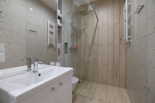 a bathroom with a toilet and a sink and a shower at Apartamenty Centrum in Białystok