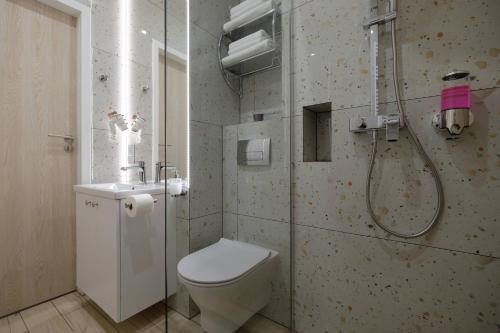 a bathroom with a shower and a toilet and a sink at Apartamenty Centrum in Białystok
