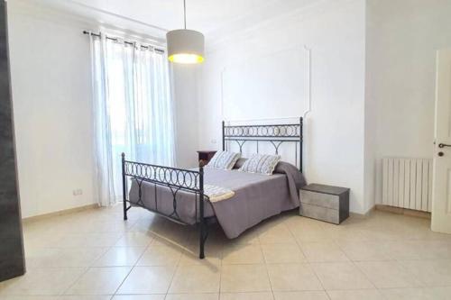a bedroom with a bed in a white room at La Torretta Nettuno in Nettuno