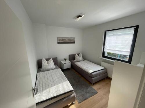 1 Schlafzimmer mit 2 Betten und einem Fenster in der Unterkunft Schönes Reihenhaus mit Garten in Magdeburg