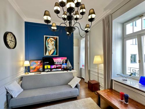 a living room with a couch and a clock at DECOR metro WiFi 300 Mbs 65TV Netflix HBO in Warsaw