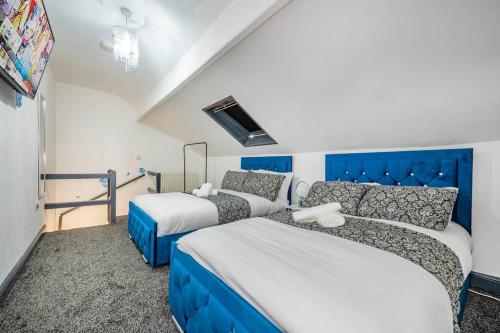 een slaapkamer met 2 bedden en een blauw hoofdeinde bij *15w* setup for your most amazing & relaxed stay + Free Parking + Free Fast WiFi * in Beeston Hill