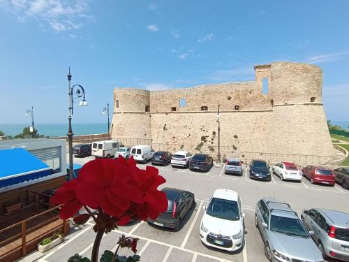 un parcheggio con auto parcheggiate di fronte a un castello di OH CHE BEL CASTELLO a Ortona
