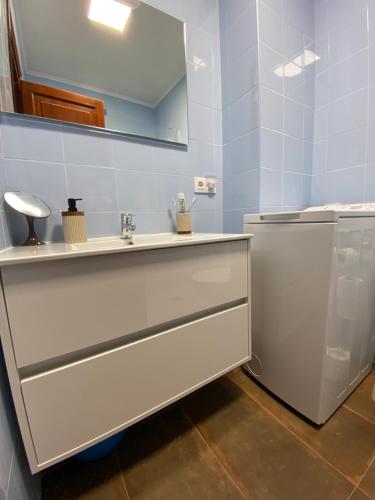 uma casa de banho com um lavatório e um espelho em Siestamar em Cala'n Porter