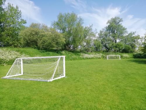 a soccer field with two goals on the grass at Lovely Lakeside lodge for families and friends in South Cerney