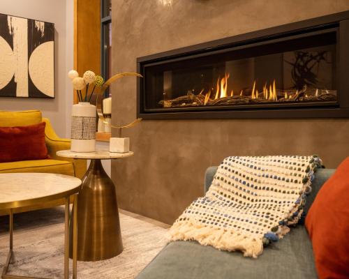 ein Wohnzimmer mit einem Kamin und einem Sofa in der Unterkunft Alpenglow Lodge Sunny Studio with Sitting Area by MVA in Whistler