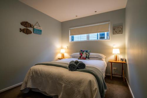 a bedroom with a bed with two towels on it at Beachside Apartment in Hokitika