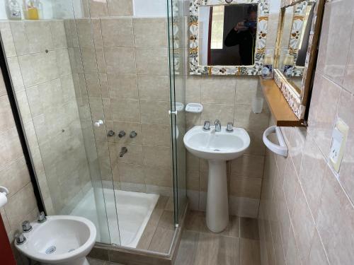 Un baño con inodoro, lavabo y ducha. en Cabañas Los 2 Algarrobos, en Santa Rosa de Calamuchita