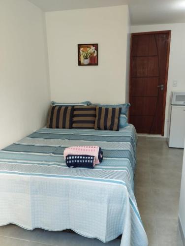 een bed met twee kussens in een kamer bij Vaccani Apart in Macaé