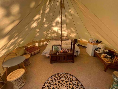 une chambre dans une tente avec un lit et une table dans l'établissement APACHE, à Loubès-Bernac