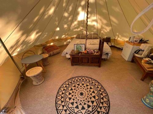 une chambre avec une tente avec un lit et une table dans l'établissement APACHE, à Loubès-Bernac