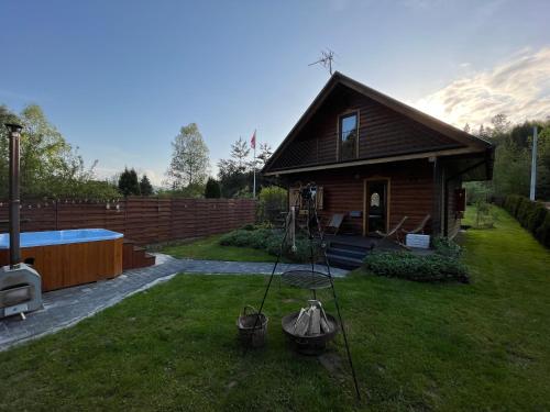 una pequeña casa con piscina en el patio en U Krysi, en Kojszówka