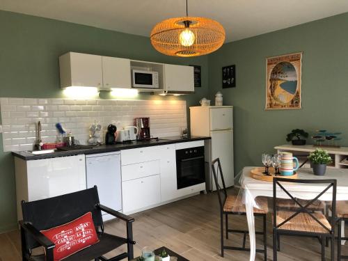 a kitchen and dining room with a table and a dining room gmaxwell gmaxwell gmaxwell gmaxwell at Le Parc plein centre près de la Grande plage in Carnac