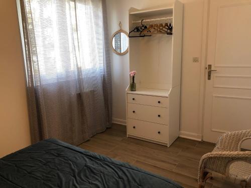 a bedroom with a bed and a dresser and a mirror at Le Parc plein centre près de la Grande plage in Carnac