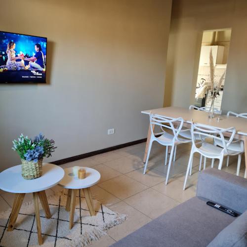 uma sala de estar com mesas e cadeiras e uma televisão em Buona Vita Departamento Alto Dorrego - Mendoza em Guaymallén