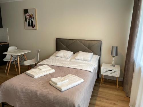a bedroom with a bed with two towels on it at Apartament Radiowa Premium in Olsztyn