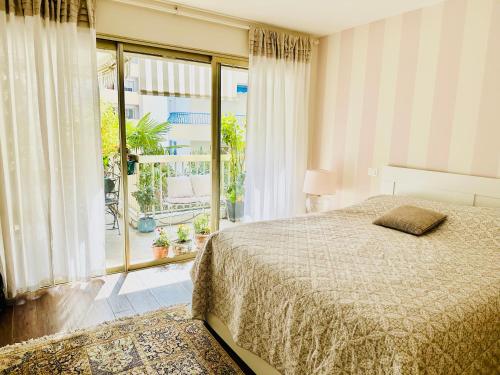 um quarto com uma cama e uma grande janela em Luxury 130m2 AC, Terrace, Pool, Parking - Steps to beach, 5 min Palais des Festivals 3BR-3BA em Cannes