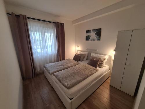 a bedroom with a bed and a large window at Apartman Zrno in Vodice