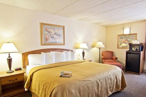 a hotel room with a bed and a chair at Quality Inn- Chillicothe in Chillicothe