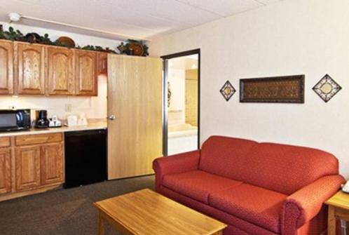 a living room with a red couch and a kitchen at Quality Inn- Chillicothe in Chillicothe