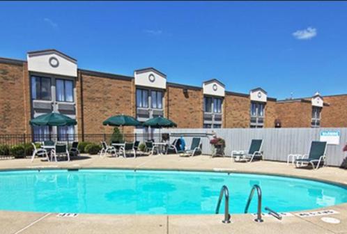 uma piscina em frente a um hotel com cadeiras e guarda-sóis em Quality Inn- Chillicothe em Chillicothe
