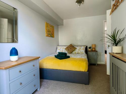 um pequeno quarto com uma cama e uma cómoda em Dove Apartments em Oxford