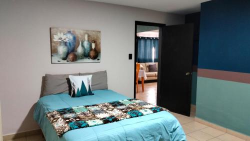 1 dormitorio con 1 cama con edredón azul en Casas centro Loreto en Loreto